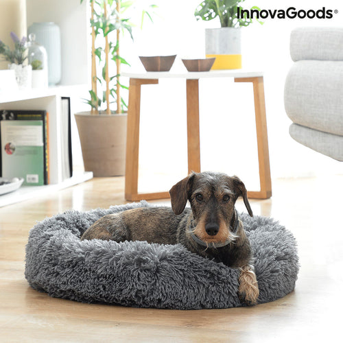 Dog lying on a gray fluffy pet bed in a home setting with 'InnovaGoods' branding.