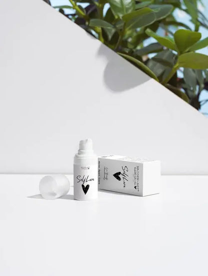 acne spot care serum displayed next to its box on a clean surface with greenery in the background.