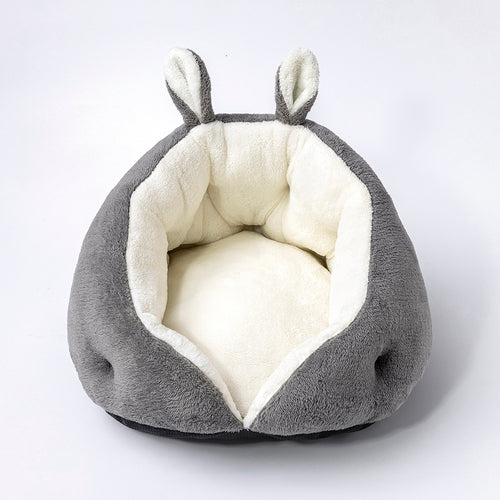 Gray pet bed with white interior and small ears on a light gray background